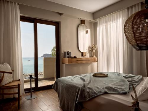a bedroom with a bed and a view of the ocean at GARDELLI RESORT in Laganas