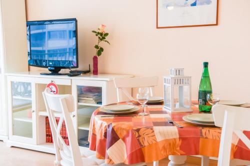 a dining room with a table and a television at Vallon des Auffes - Vue imprenable sur la mer in Marseille