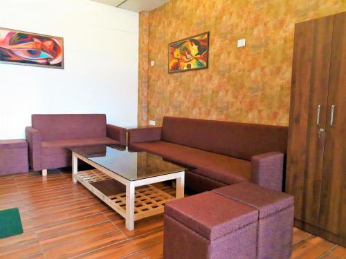 a living room with a couch and a table at Stovehouse Inn in Ambāla