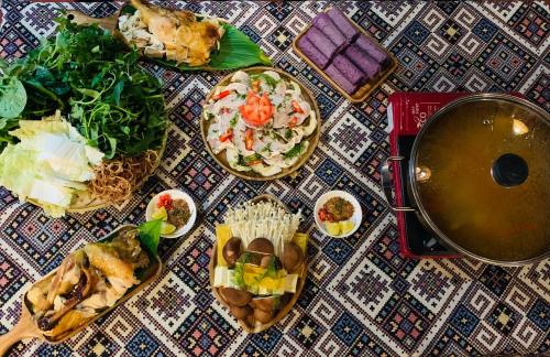 une table avec des assiettes de nourriture sur une table dans l'établissement Sapa Rosie House, à Sa Pa