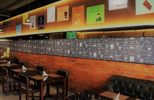 a dining room with tables and chairs and a brick wall at Stovehouse Inn in Ambāla