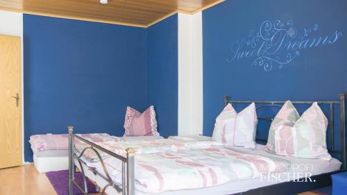 een slaapkamer met een bed met een blauwe muur bij Doppelzimmer im Zentrum von Moers in Moers