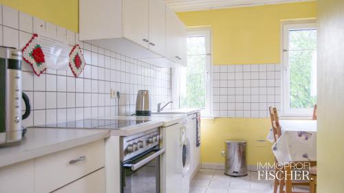 cocina con electrodomésticos blancos y paredes amarillas en Doppelzimmer im Zentrum von Moers, en Moers