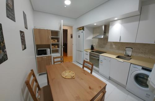 a kitchen with a wooden table and a dining room at Apartamento Saioa in Pamplona