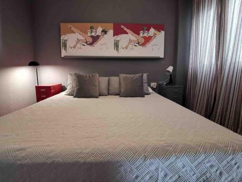 ein Schlafzimmer mit einem Bett und einem Gemälde an der Wand in der Unterkunft Cosy apartment at Unesco Heritage city in La Laguna