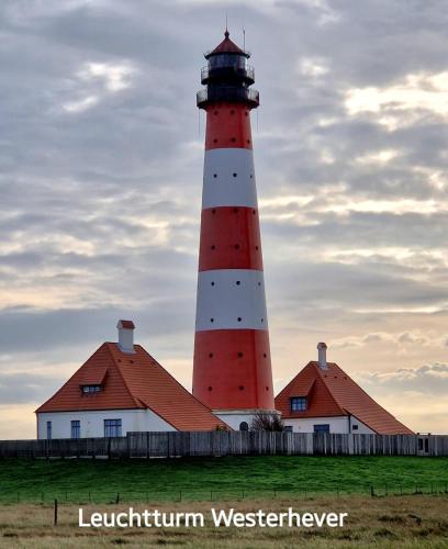 a red and white lighthouse in front of a building at Ferienwohnung Ilsebill in Husum