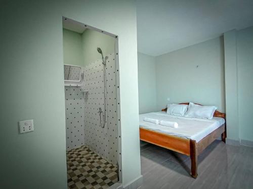 um quarto com um chuveiro e uma cama com um espelho em Ching Ching Guest House em Sihanoukville
