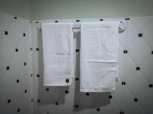 dwa ręczniki wiszące na wieszaku w łazience w obiekcie Ching Ching Guest House w mieście Preăh Sihanŭk