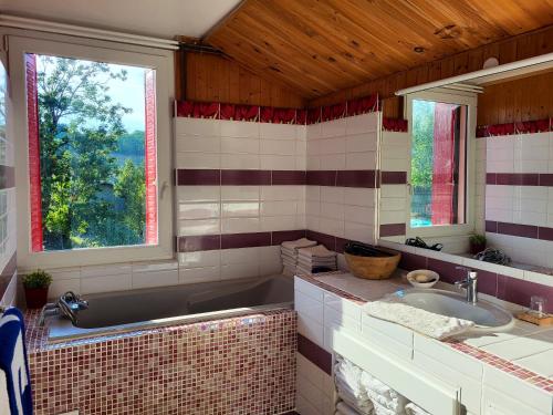 La salle de bains est pourvue d'un lavabo, d'une baignoire et d'une fenêtre. dans l'établissement Appartement de 3 chambres avec jardin clos et wifi a Mont Saxonnex, à Mont-Saxonnex