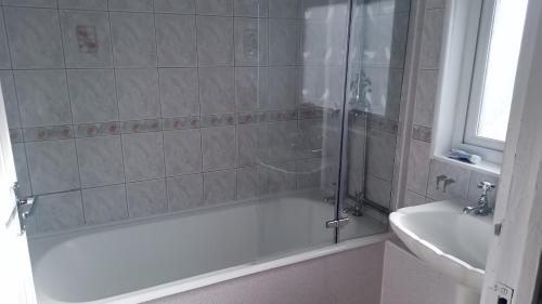 a bathroom with a shower and a tub and a sink at 21 Orion drive in Bristol