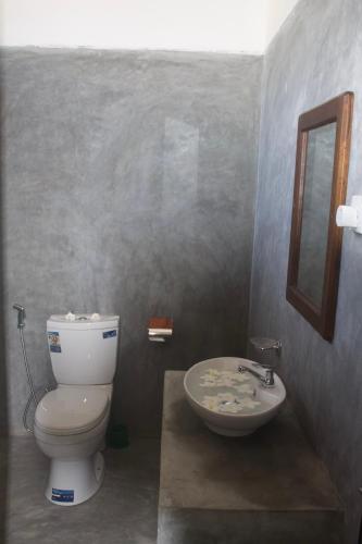 a bathroom with a toilet and a sink at Emma's Sea View in Hiriketiya