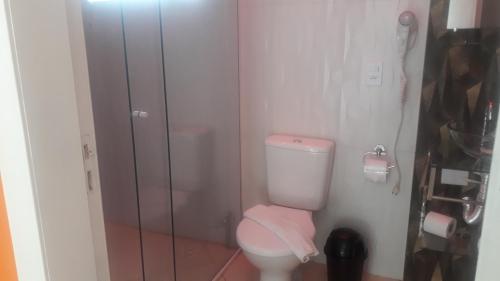 a bathroom with a toilet and a glass shower at Parada Di Maria Guest House in Campos do Jordão