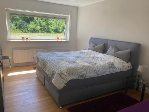 a bedroom with a large bed with a window at Eifel Relax in Hillesheim