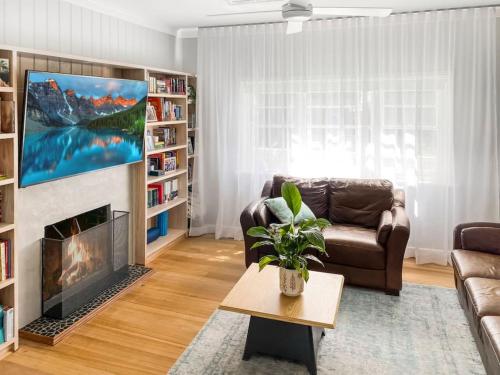 Una sala de estar con un sofá y una chimenea. en Coastal Charm Dog Friendly home by Custom Bnb Hosting, en Dromana