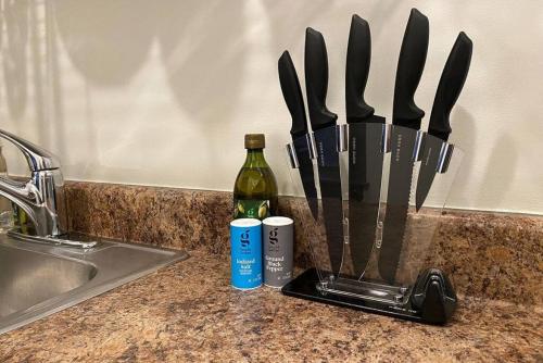 a knife block next to a sink and a bottle of wine at Deluxe 5-bedroom Walk everywhere in Over the Rhine in Cincinnati