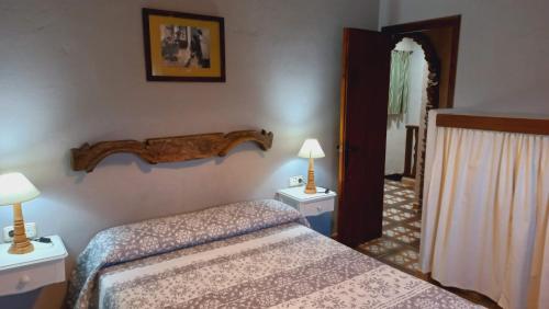 BenalauríaにあるCasa El Olivo by CasaTuristicaのベッド1台と2泊用のスタンドが備わるホテルルームです。