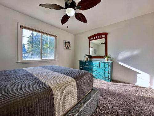 a bedroom with a ceiling fan and a dresser with a mirror at King Bed-Huge Yard-Quiet Neighborhood-Garage in Sacramento