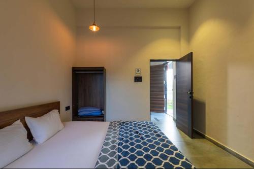 a bedroom with a bed and a door to a room at Two Villa by StayVista with Infinity Pool, Farm & Mountain Views, Modern Interiors in Karjat