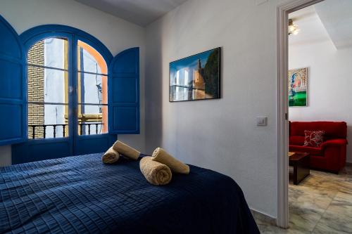 a bedroom with a blue bed with two pillows on it at More Center Apartment in Seville
