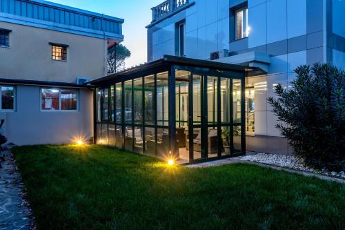 a glass house with lights in the yard at Hotel La Quercia in Mozzo