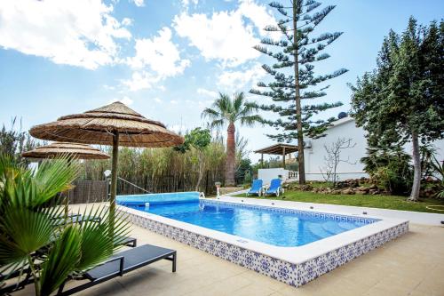 a swimming pool in a yard with an umbrella at villa yvonne,private pool,private parking 1,7 km from the beach in Albufeira