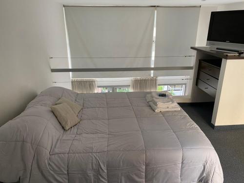 1 dormitorio con 1 cama y Tv LED en FREIRE SUITES con cochera en Buenos Aires
