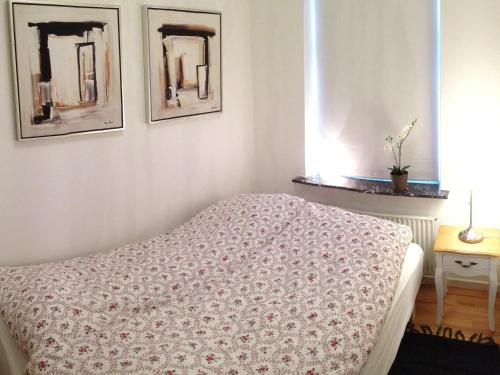 ヘアニングにあるHerning City Apartmentsのベッドルーム1室(ベッド1台付)が備わります。壁に2枚の写真が飾られています。