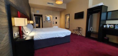 a hotel room with a large bed and a tv at The John Francis Basset Wetherspoon in Camborne