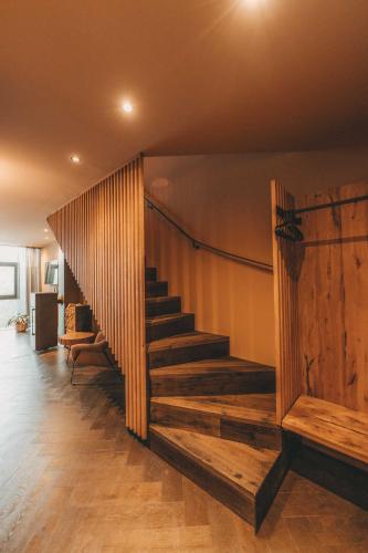 a staircase in a room with a wooden wall at Hüttendorf Schlögelberger in Sankt Margarethen im Lungau