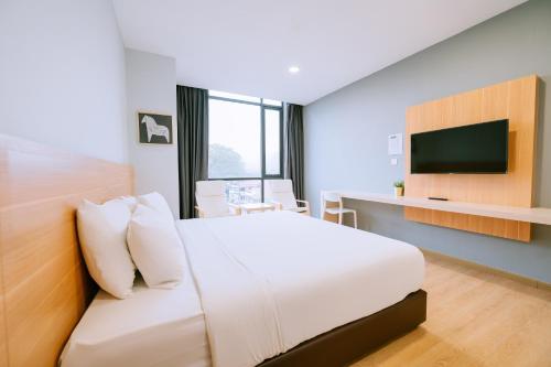 um quarto de hotel com uma cama e uma televisão em Chill Suites Langkawi em Kuah