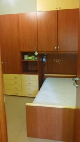 a small kitchen with wooden cabinets and a bed at Residenza nel borgo romano in Mentana
