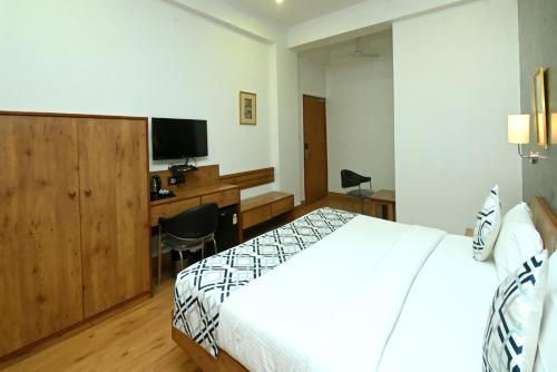 a hotel room with a bed and a desk at Hotel Yulia in Jaipur
