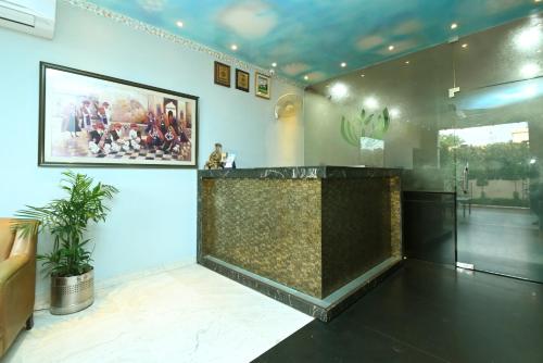 a lobby with a counter and a painting on the wall at Hotel Yulia in Jaipur