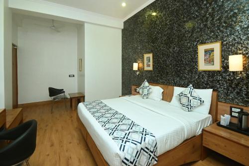 a bedroom with a bed and a black wall at Hotel Yulia in Jaipur