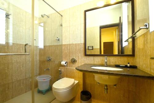 a bathroom with a sink and a toilet and a mirror at Hotel Yulia in Jaipur