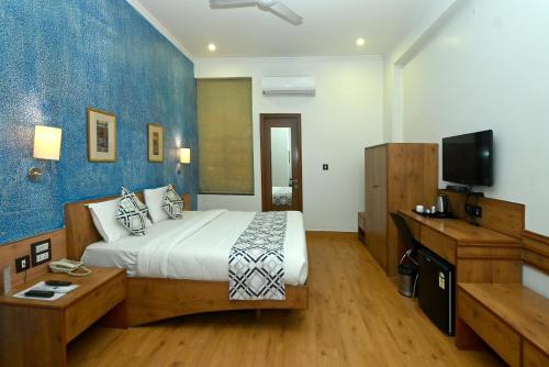 a hotel room with a bed and a television at Hotel Yulia in Jaipur