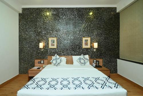 a bedroom with a bed and a black wall at Hotel Yulia in Jaipur