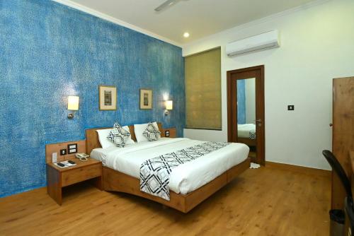 ein Schlafzimmer mit einem großen Bett und einer blauen Wand in der Unterkunft Hotel Yulia- Le Amour Inn in Jaipur