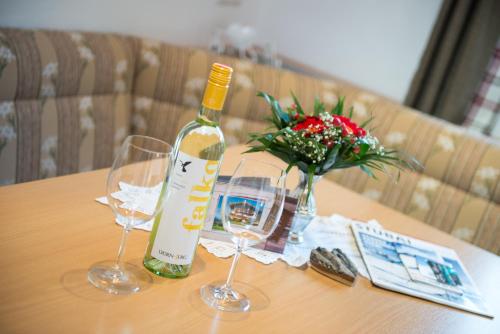 a bottle of wine and two glasses on a table at Haus Fernblick in Neustift im Stubaital
