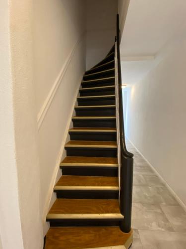 a staircase with wooden treads in a white wall at FeWo Meeres Luft in Wismar