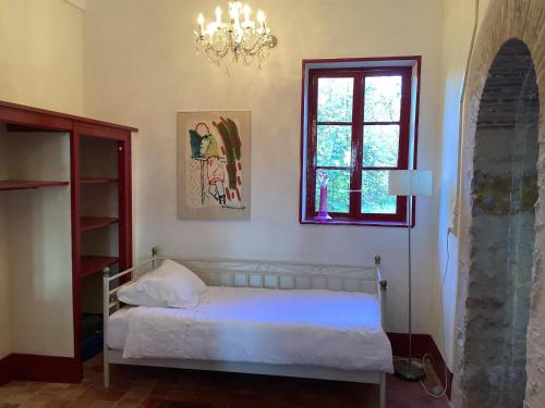 a bedroom with a bed and a window and a chandelier at Pleasant cottage in Le Veurdre with private garden in Le Veurdre