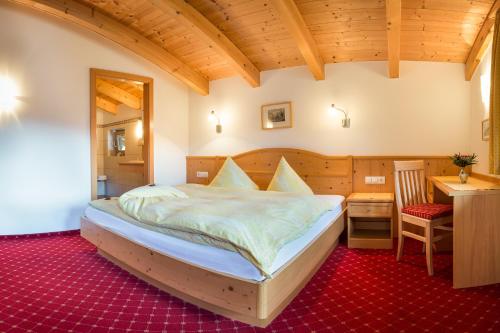 a bedroom with a bed and a table and a desk at Haus Fernblick in Neustift im Stubaital