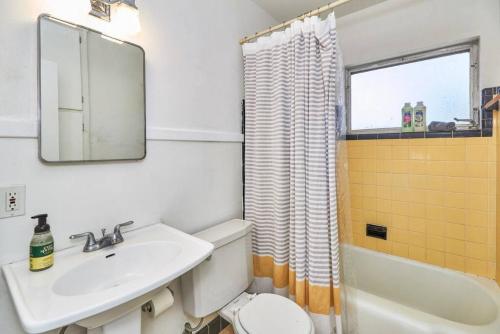 a bathroom with a sink and a toilet and a mirror at Vinoy Beach getaway Fun in the Sun Close to bars in St. Petersburg
