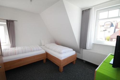 a room with two beds and a window at Lüttje Gesine Lüttje Gesine in Norderney
