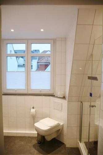 a bathroom with a toilet and a window at Lüttje Gesine Lüttje Gesine in Norderney