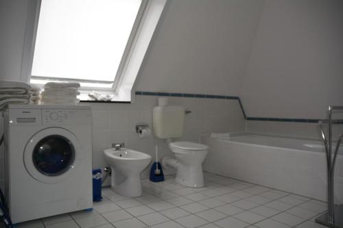 a bathroom with a washing machine and a toilet at Up Süderdün 7 Up Süderdün 7 in Norderney