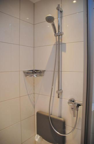 La salle de bains est pourvue d'une douche avec un pommeau de douche. dans l'établissement Metropol Metropol 23, à Norderney
