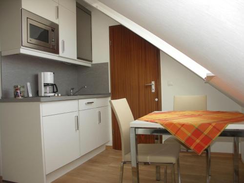 a kitchen with a table with chairs and a microwave at Whg Salverius Whg Salverius in Norderney