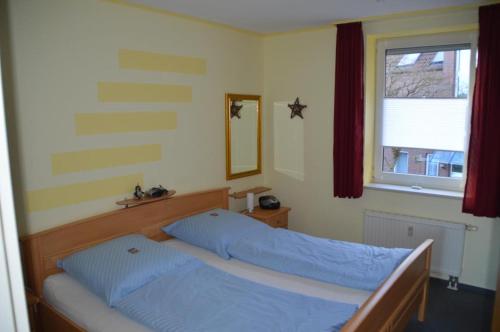 1 Schlafzimmer mit 2 Betten und einem Fenster in der Unterkunft Residenz am Deich NDD 12 in Norden