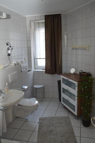 ein weißes Bad mit einem WC und einem Waschbecken in der Unterkunft Residenz am Deich NDD 12 in Norden